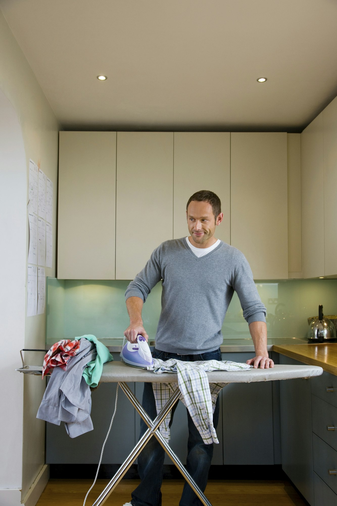 Man confidently tackling the ironing in a sunlit home